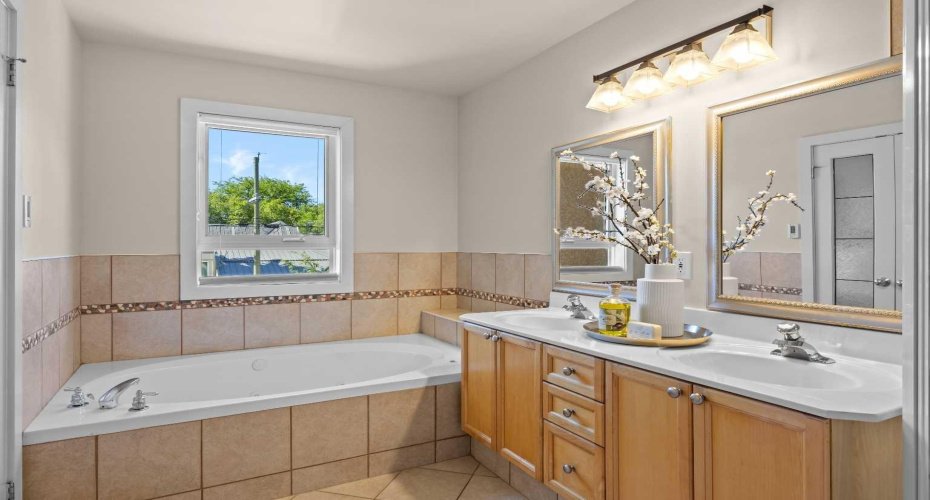A deep jetted soaker tub tucked beneath a window makes for a relaxing soak after a long day.