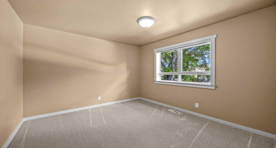 Natural light fills this upper-level bedroom, offering comfortable space to unwind.