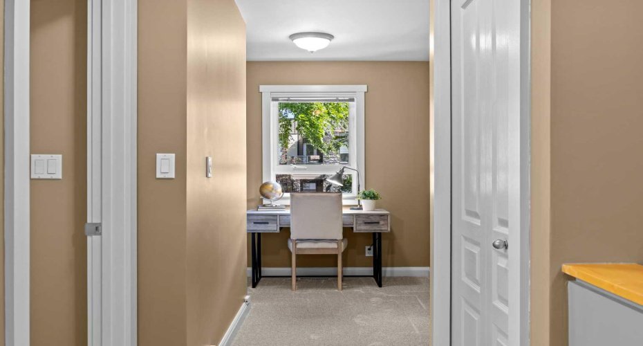 A charming study nook on the upper level offers a bright spot to work or read, overlooking the tree-canopied street.