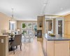 The heart of the home opens beautifully from kitchen to dining to living space, all connected by warm hardwood floors.