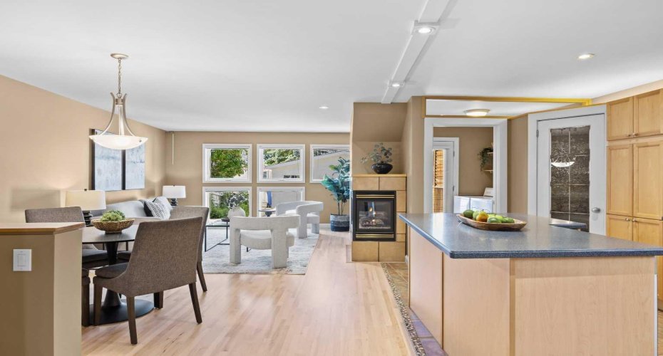 The heart of the home opens beautifully from kitchen to dining to living space, all connected by warm hardwood floors.