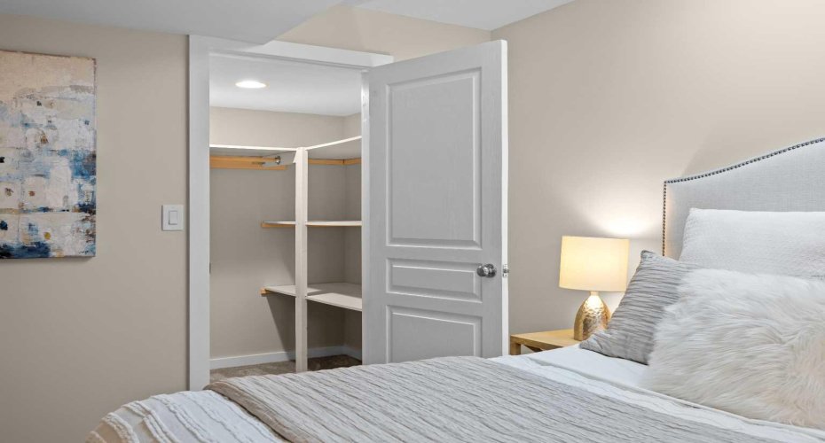 A generous walk-in closet offers custom shelving right off the second bedroom.