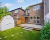 The backyard deck offers a private, low-maintenance outdoor space with a screened privacy wall and storage shed.
