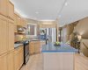 A functional kitchen layout centers on a spacious island, with warm wood cabinetry and stainless appliances throughout.