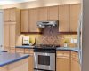 A closer look at the kitchen's tiled backsplash and gas range highlights the everyday comfort built into this space.
