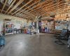 West Side of the unfinished basement (walk-up roughed in behind red shelving) 9.5' ceiling height & SIX windows down here!!