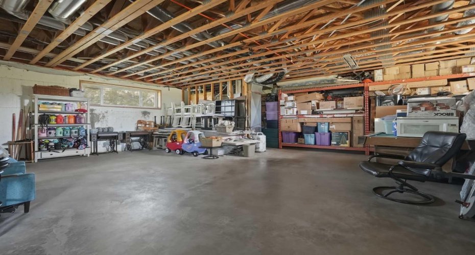 West Side of the unfinished basement (walk-up roughed in behind red shelving) 9.5' ceiling height & SIX windows down here!!