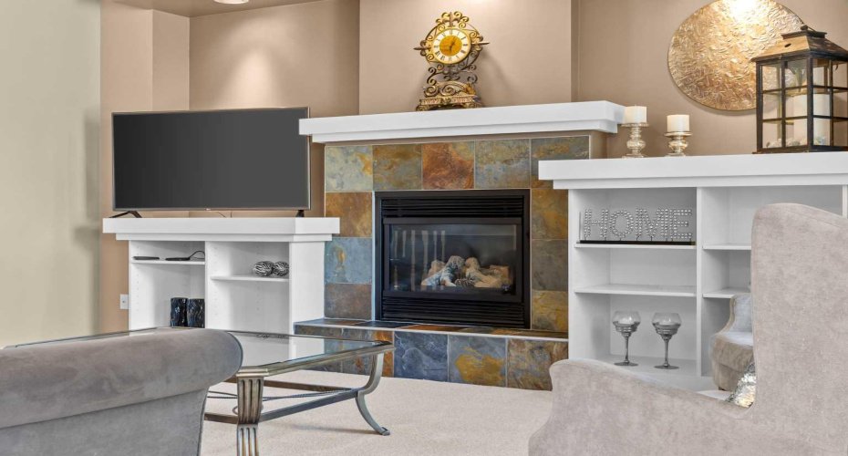 A slate tiled fireplace with custom white built ins offers a cozy focal point for movie nights or quiet evenings in. A slate tiled fireplace with custom white built ins offers a cozy focal point for movie nights or quiet evenings in.