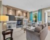 Pops of teal and soft neutrals bring warmth to this inviting living room, anchored by a floor to ceiling stone fireplace. Pops of teal and soft neutrals bring warmth to this inviting living room, anchored by a floor to ceiling stone fireplace.