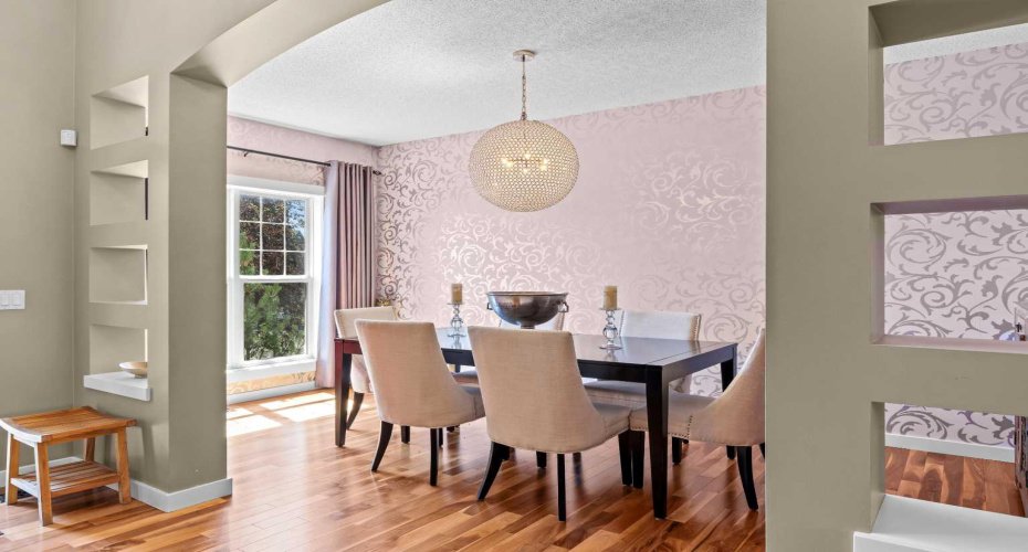 An elegant formal dining room sets a sophisticated tone, with statement wallpaper and a striking globe chandelier. An elegant formal dining room sets a sophisticated tone, with statement wallpaper and a striking globe chandelier.