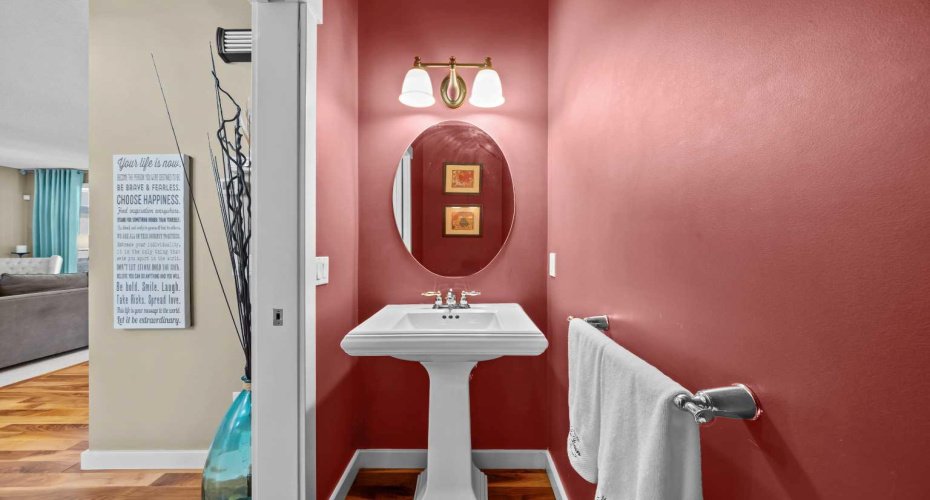 A stylish powder room on the main floor makes a bold statement with rich color and a pedestal sink, perfect for guests. A stylish powder room on the main floor makes a bold statement with rich color and a pedestal sink, perfect for guests.