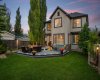 As twilight settles in, the back of the home glows warmly, showcasing the expansive deck and towering mature trees that frame the yard. As twilight settles in, the back of the home glows warmly, showcasing the expansive deck and towering mature trees that frame the yard.