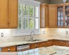 A window over the sink brings in natural light while overlooking the lush backyard, a lovely spot for everyday tasks. A window over the sink brings in natural light while overlooking the lush backyard, a lovely spot for everyday tasks.