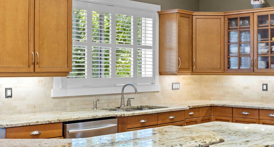 A window over the sink brings in natural light while overlooking the lush backyard, a lovely spot for everyday tasks. A window over the sink brings in natural light while overlooking the lush backyard, a lovely spot for everyday tasks.