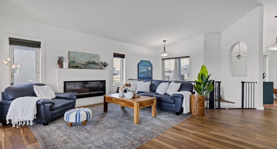Spacious living room with upgraded railings and cozy fireplace