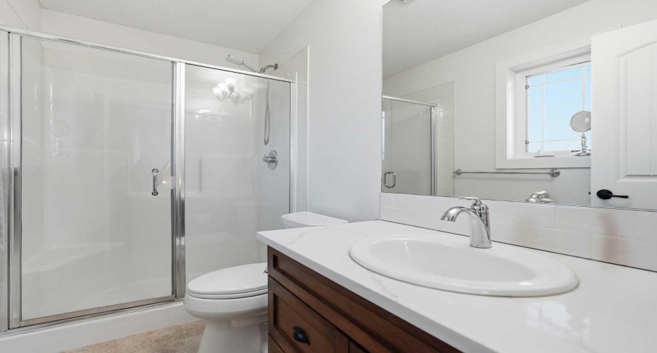 Clean, functional 3 piece ensuite bathroom with rich solid maple shaker cabinets & quarts countertops.