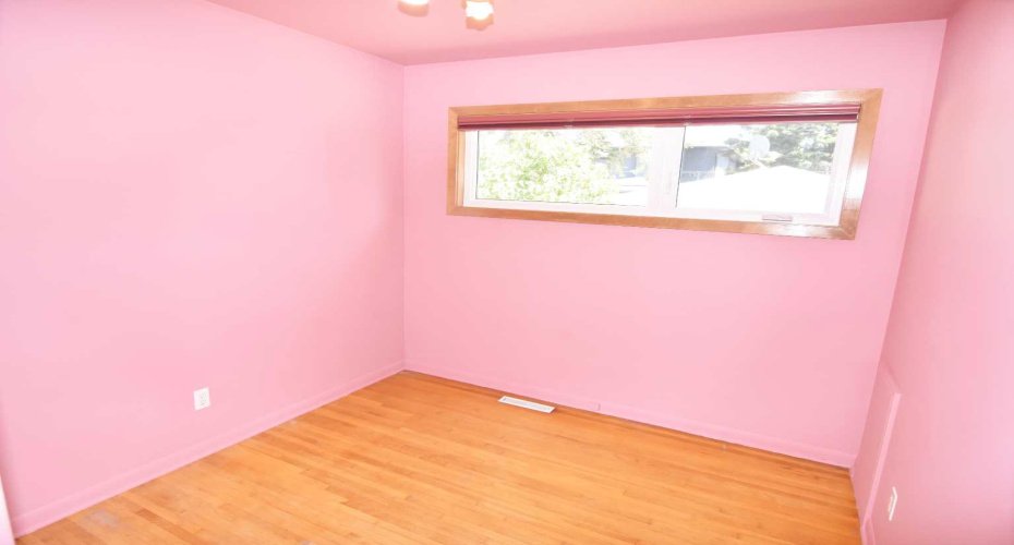 Second bedroom with hardwood floors and mirrored closet doors