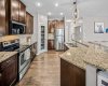 Dark wood cabinetry, stainless appliances and granite counters create a timeless kitchen.