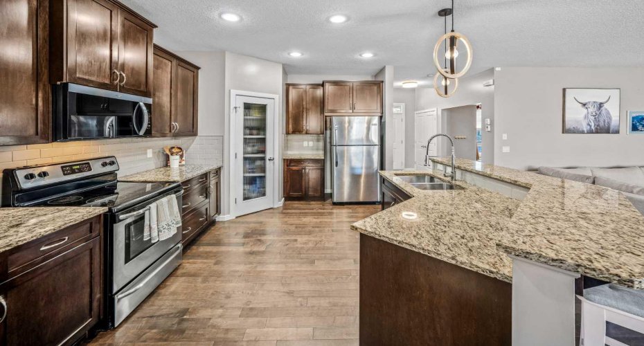 Dark wood cabinetry, stainless appliances and granite counters create a timeless kitchen.
