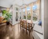 The dining area is surrounded by windows and enjoys beautiful natural light.