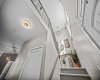 A wide staircase and open stairwell create an airy and welcoming transition to the upper level.