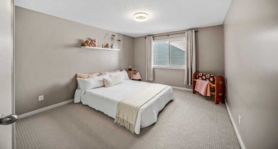 A comfortable secondary bedroom with neutral finishes and generous floor space.