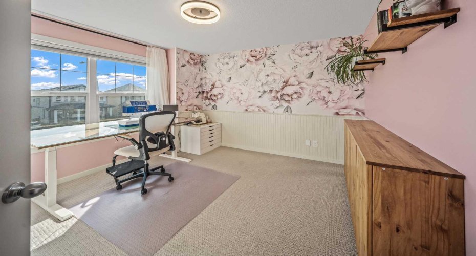 The front bedroom features charming wainscoting and statement floral wallpaper, creating a memorable and versatile space.