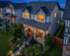 Welcoming twilight exterior with warm interior lighting and beautifully established front gardens.
