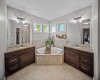 The spacious ensuite features dual vanities and a corner soaker tub.