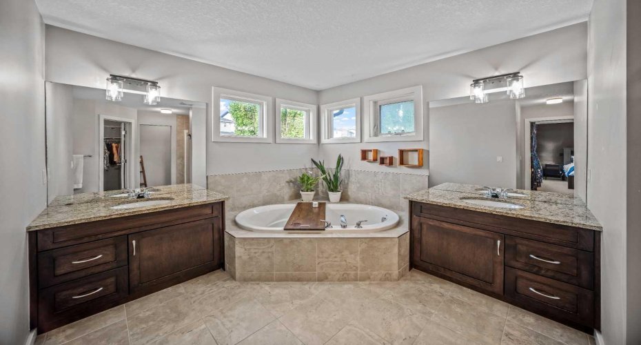 The spacious ensuite features dual vanities and a corner soaker tub.