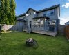 The fenced backyard offers a spacious lawn, deck and room to gather outdoors.