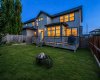 Twilight backyard view with warm interior light creating an inviting evening atmosphere.