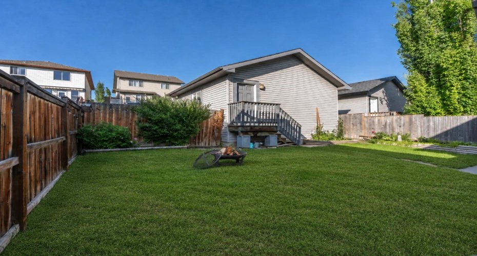 A second backyard perspective shows the lawn, detached garage and private fencing.