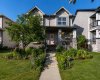 Charming front exterior with a covered porch, mature landscaping and colourful perennial gardens.
