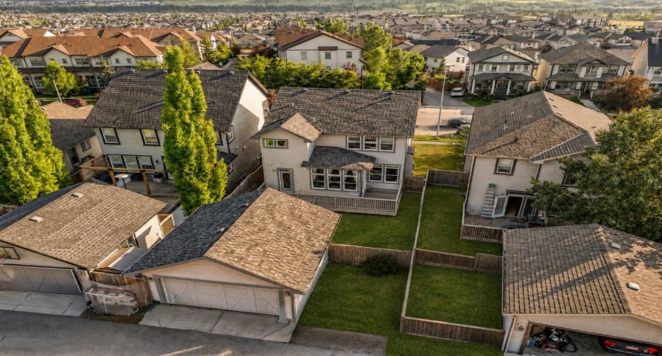 Aerial view highlights the detached garage, additional parking pad, backyard and surrounding neighbourhood.