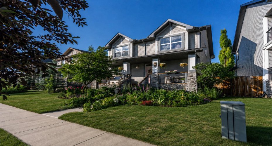 A second front perspective highlights the inviting porch and thoughtful garden design.