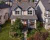 Elevated front view showcasing the home, porch and lush garden beds.